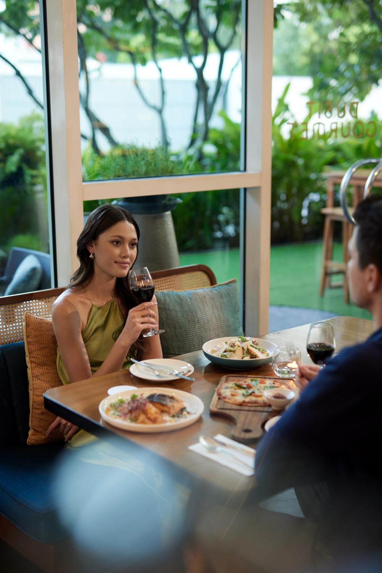 Dusit Suites Hotel Ratchadamri, Bangkok Buitenkant foto A woman drinking wine